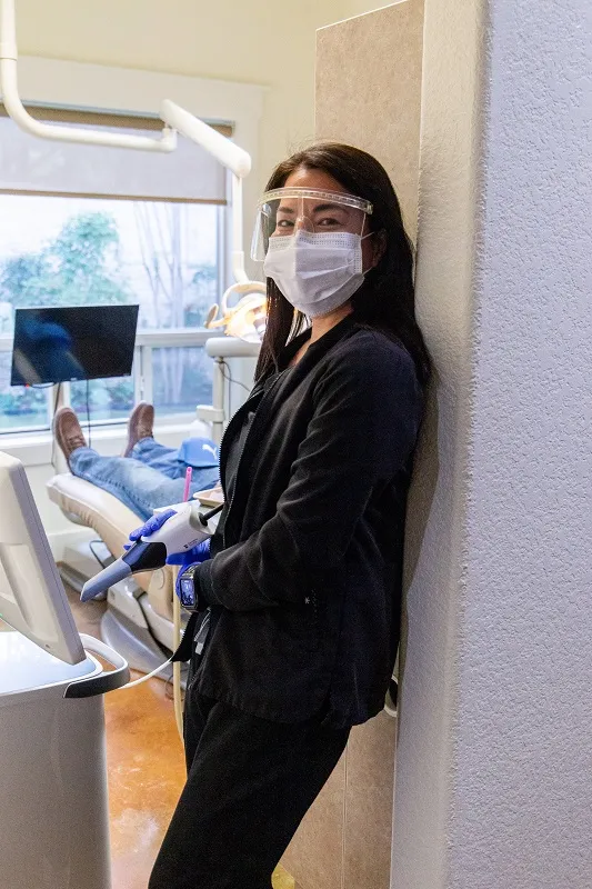 Female doctor in scrubs with mask in a dental office