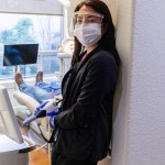 Female doctor in scrubs with mask in a dental office
